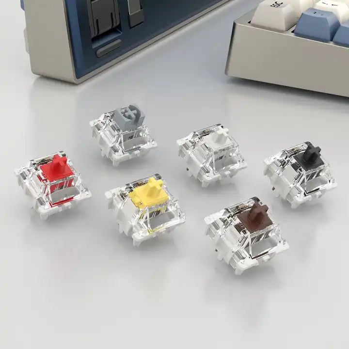 Zes mechanische keyboard switches in verschillende kleuren en typen, waaronder rood, grijs, wit, geel, bruin en zwart – geschikt voor custom mechanical keyboards.