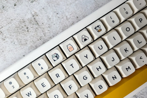 Close-up van vrolijke Honey Milk keycaps – perfect voor creatieve typisten