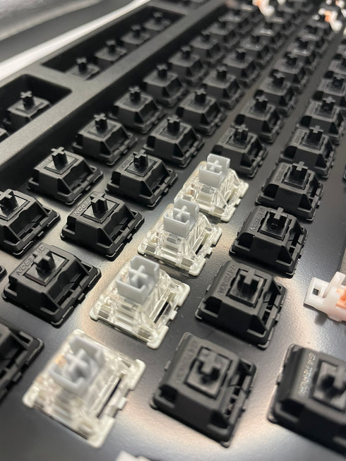 Top-down view of a keyboard with a row of Gateron SMD Silver Pro switches installed in the center.