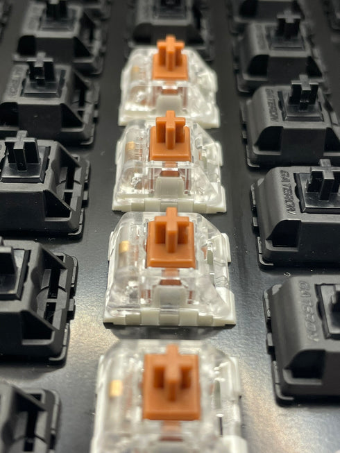 Kailh Speed Bronze switches op een toetsenbord tussen zwarte switches – bovenaanzicht