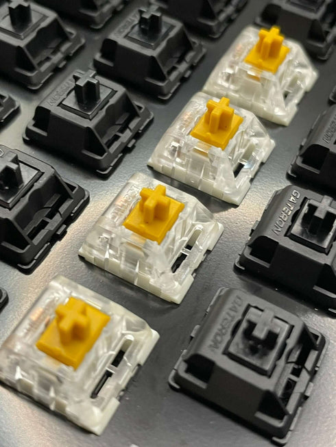 Angled shot of Kailh Speed Golden switches installed on a mechanical keyboard, showing stem alignment.