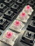 Kailh Speed Pink switches installed on a hot-swap board among black Gateron switches, viewed from the left side.