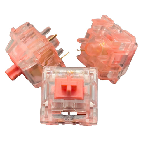 Drie KTT Strawberry switches in verschillende hoeken – roze stem, heldere behuizing