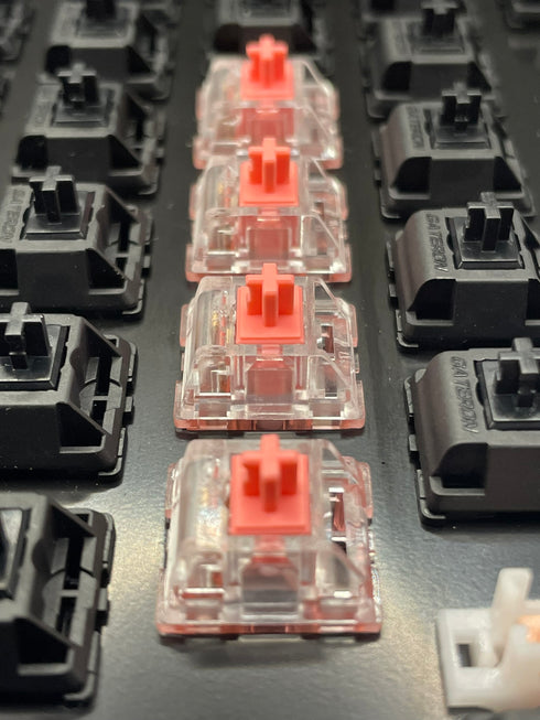 Rij KTT Strawberry switches in een toetsenbord, gemonteerd naast zwarte switches – bovenaanzicht