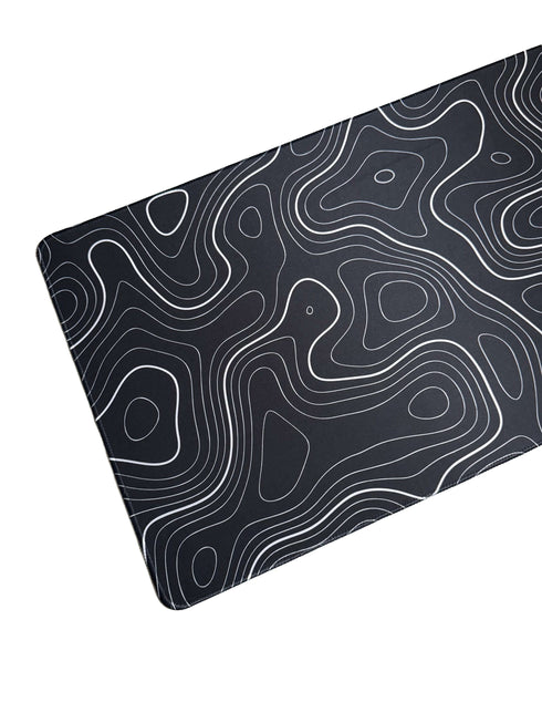 Muismat met wit lijnenspel op zwarte achtergrond – topografisch geïnspireerd ontwerp in XXL formaat
